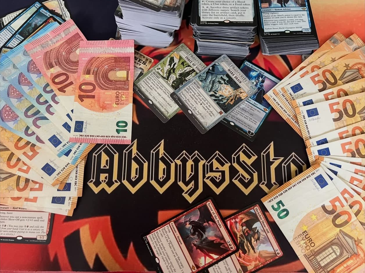 Magic: The Gathering cards and euro banknotes on an AbbysStore playmat